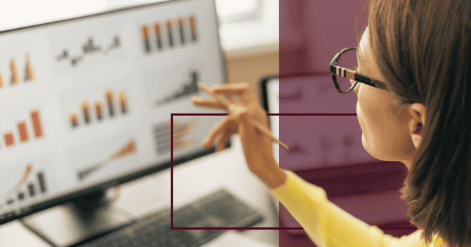 woman looking at data on a computer while pointing at it