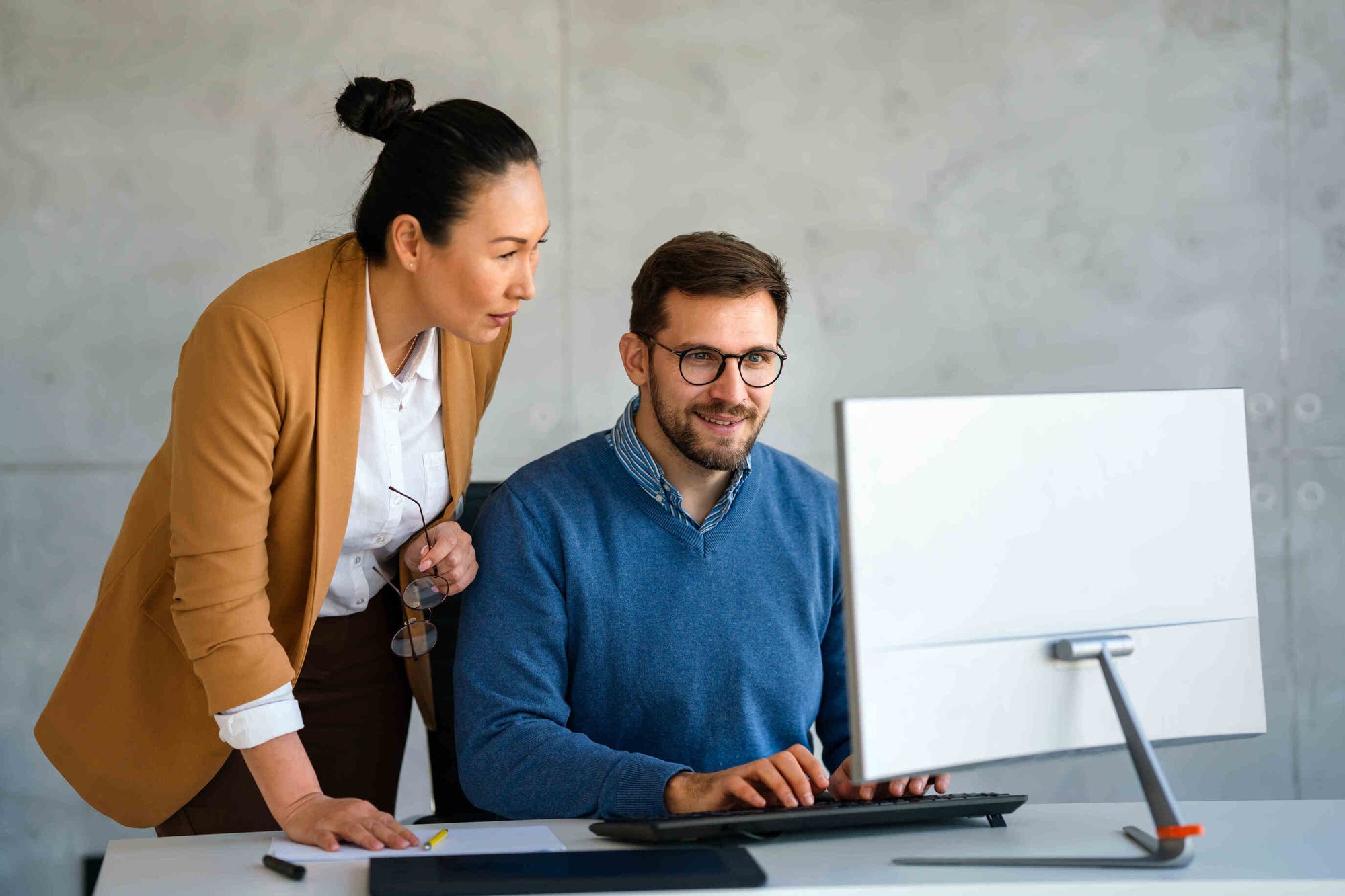 Two HR Tech workers looking at a computer