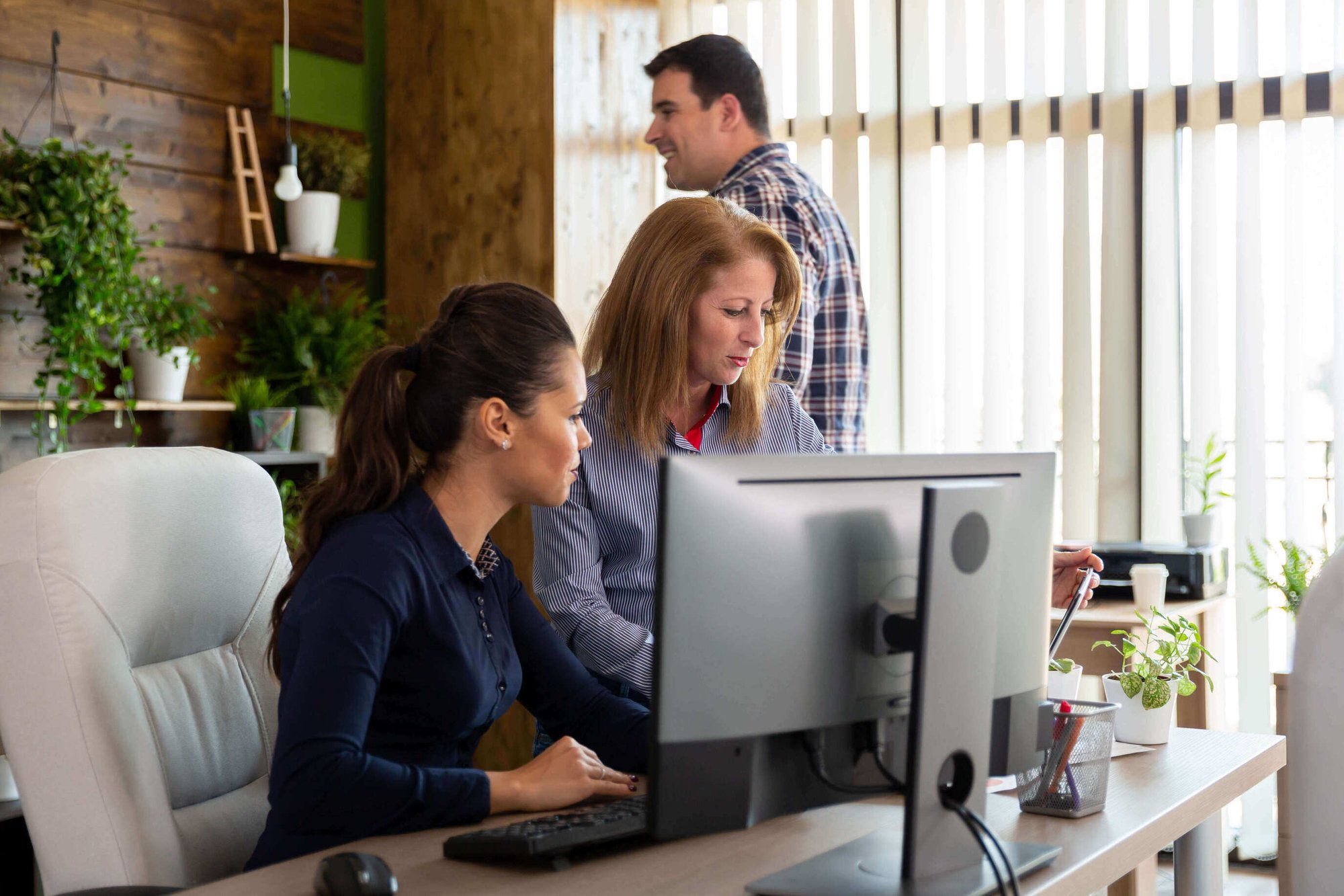 Two people working on monitoring ACA compliance in office