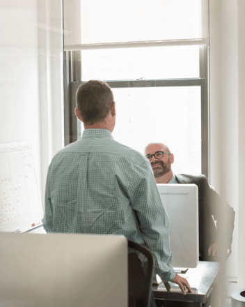 HR professional talking to someone in their office about SCA compliance