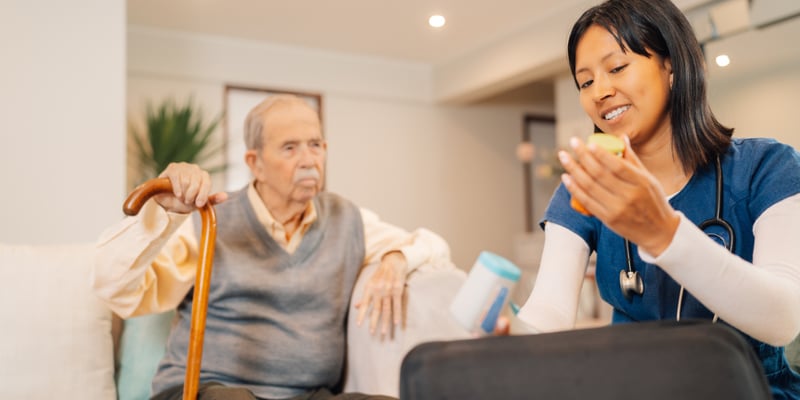 a nurse gets an older patient's pills ready