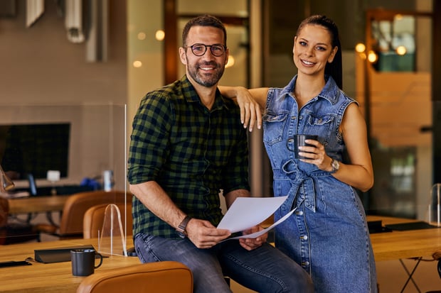 Two business owners smiling at the camera