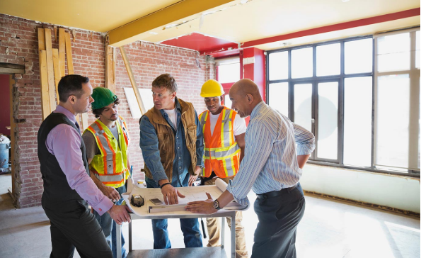 construction crew gathered around a table talking