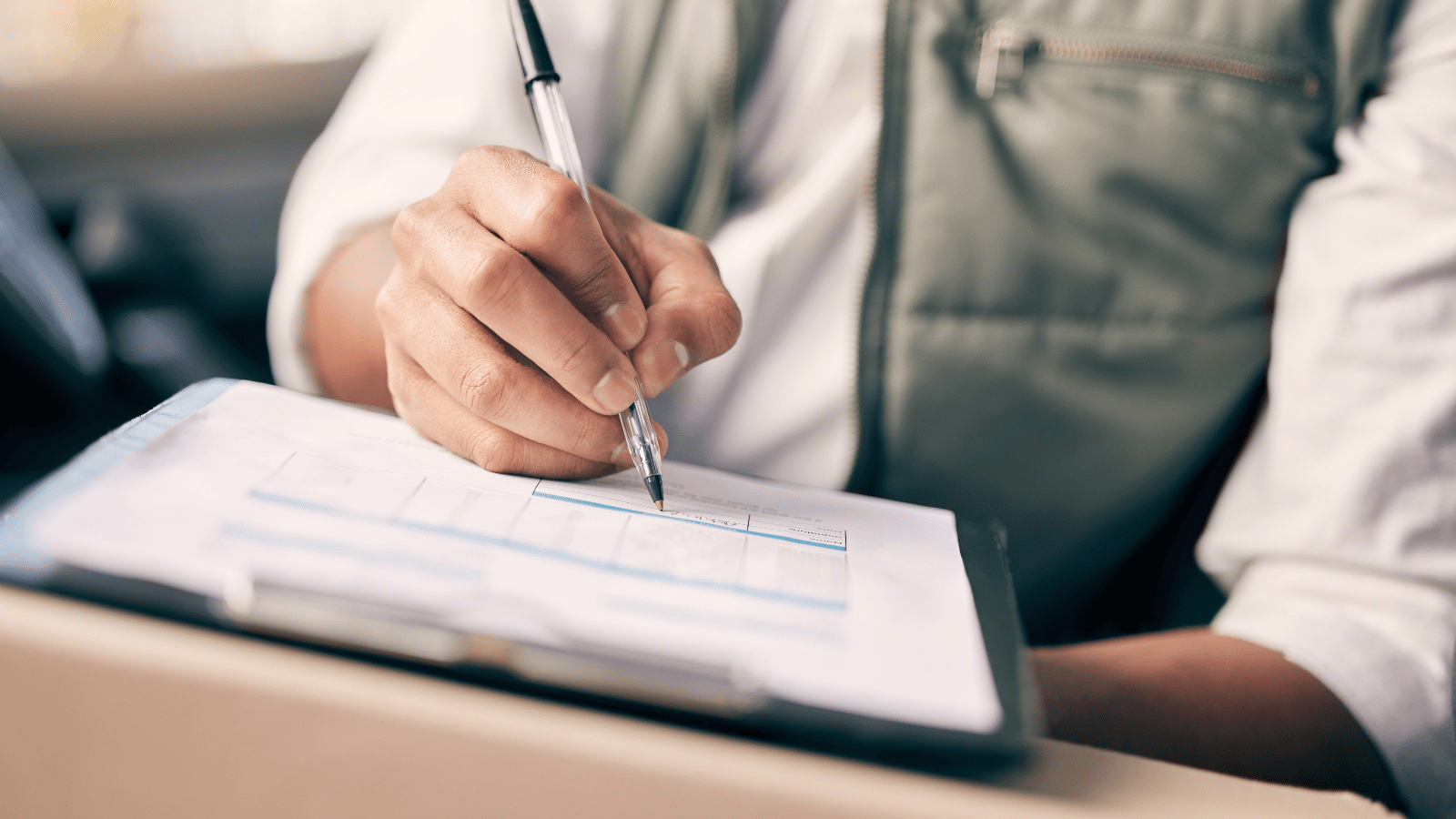 man fills out a form on a clipboard