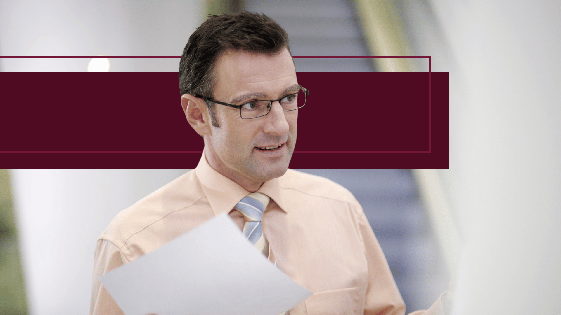 an HR professional looking at paperwork and talking to coworker in office