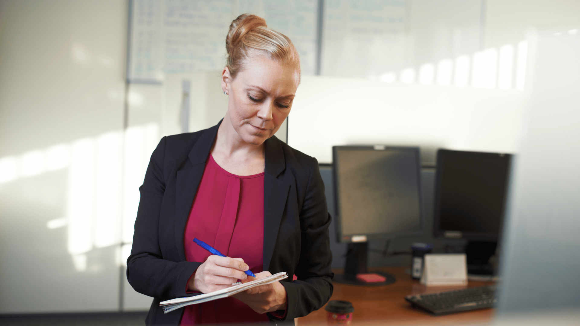 hr professional writing notes on a pad in her office