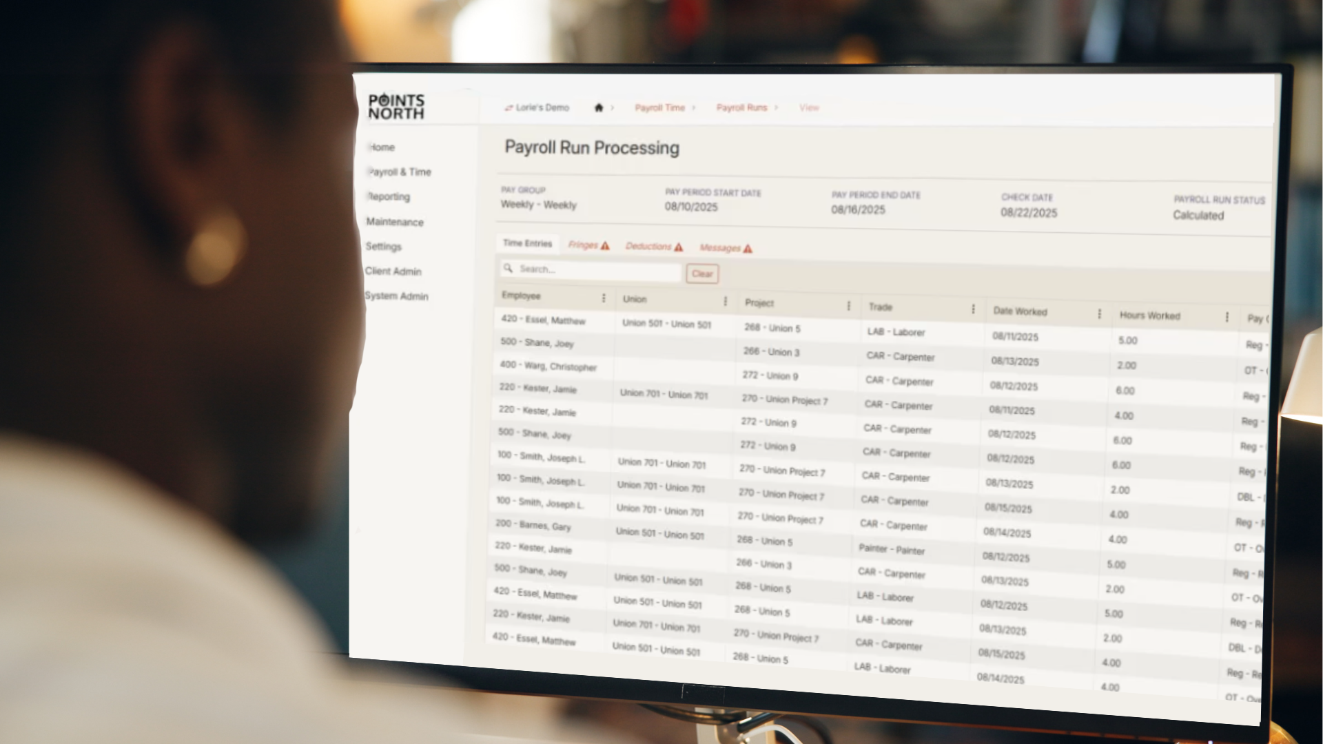 woman looking at her desktop computer with Points North's WageIQ product page