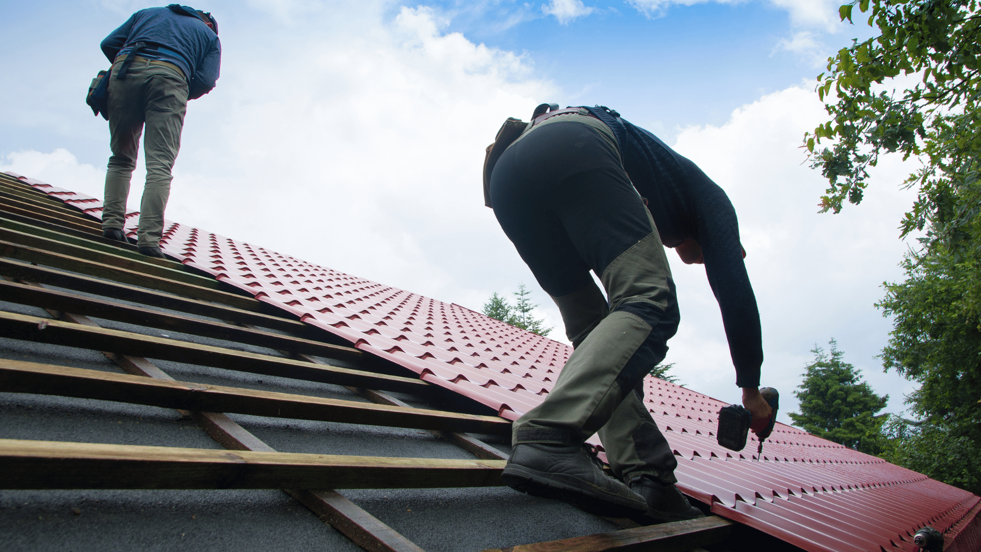 workers installing clay tiles on a roof