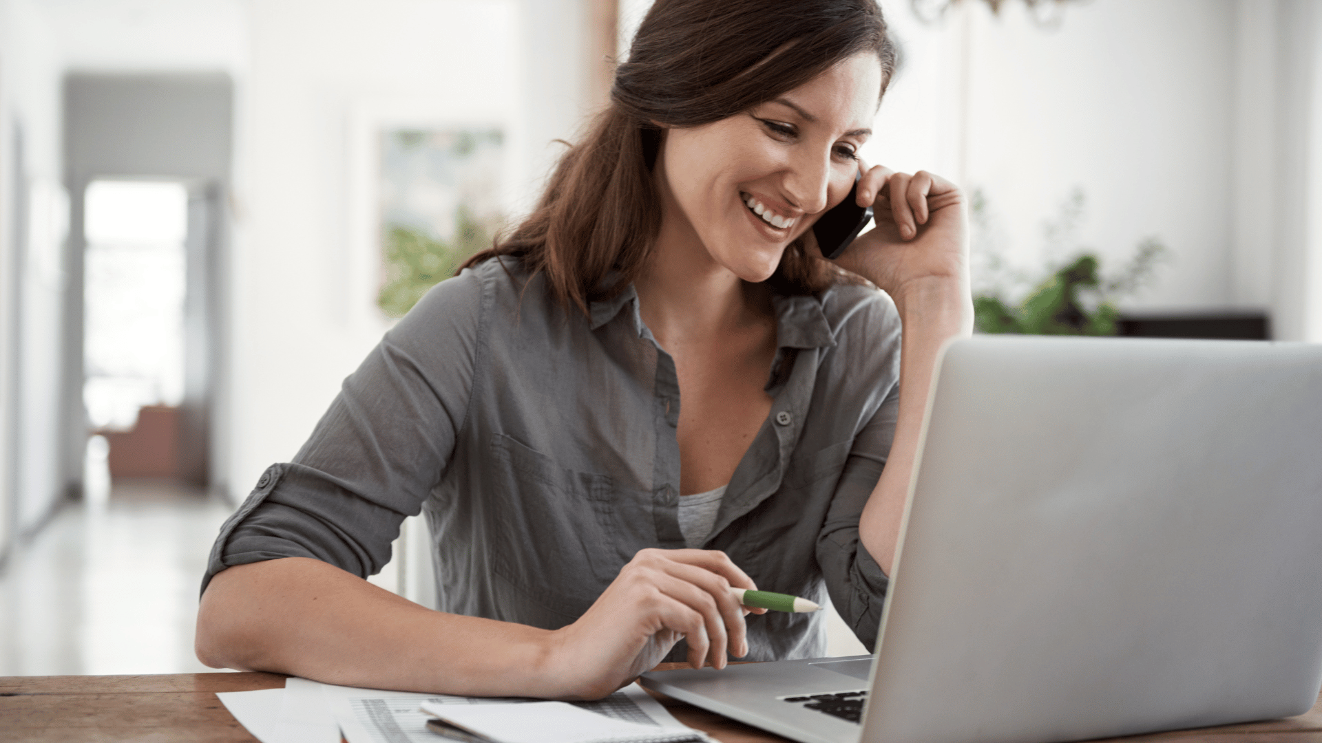 woman talking on phone and working on computer