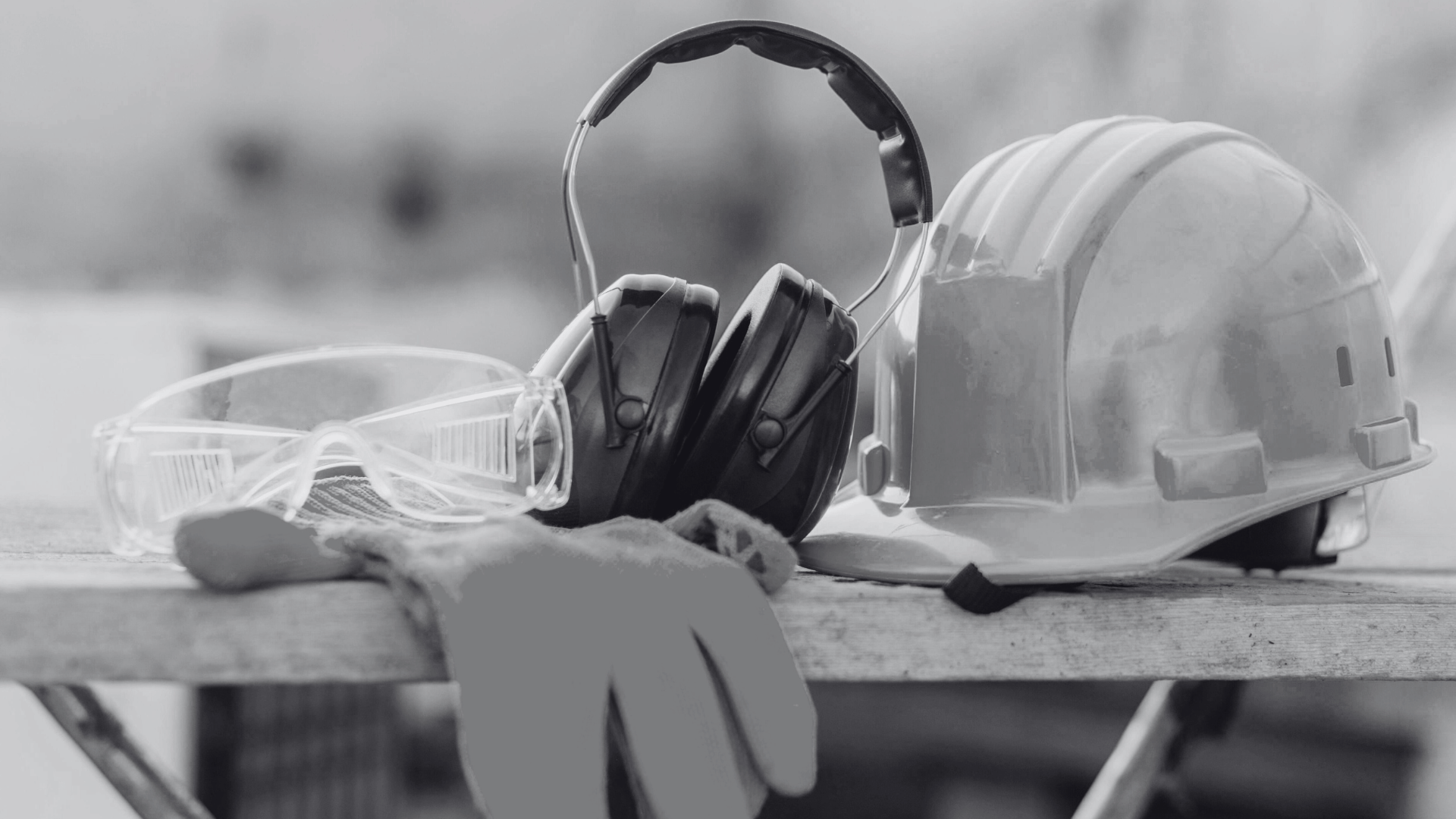 hard hat, gloves, safety glasses, and ear muffs on a table
