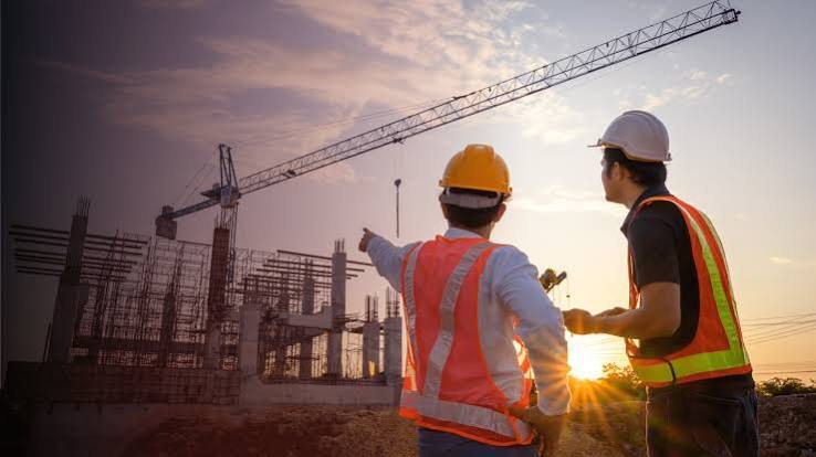 two construction workers pointing at a construction site two construction workers pointing at a construction site